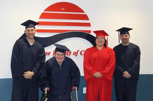 preferred-skills-Four NetTEL USA graduates in robes and hats.